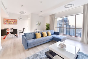 Relax in a spacious living area with a sofa, coffee table, and city view.