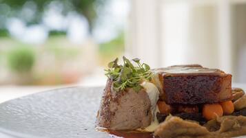 A plated dish with meat, vegetables, and a garnish.