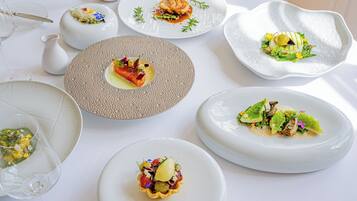 Une table dressée avec différents plats, des verres et une carafe.