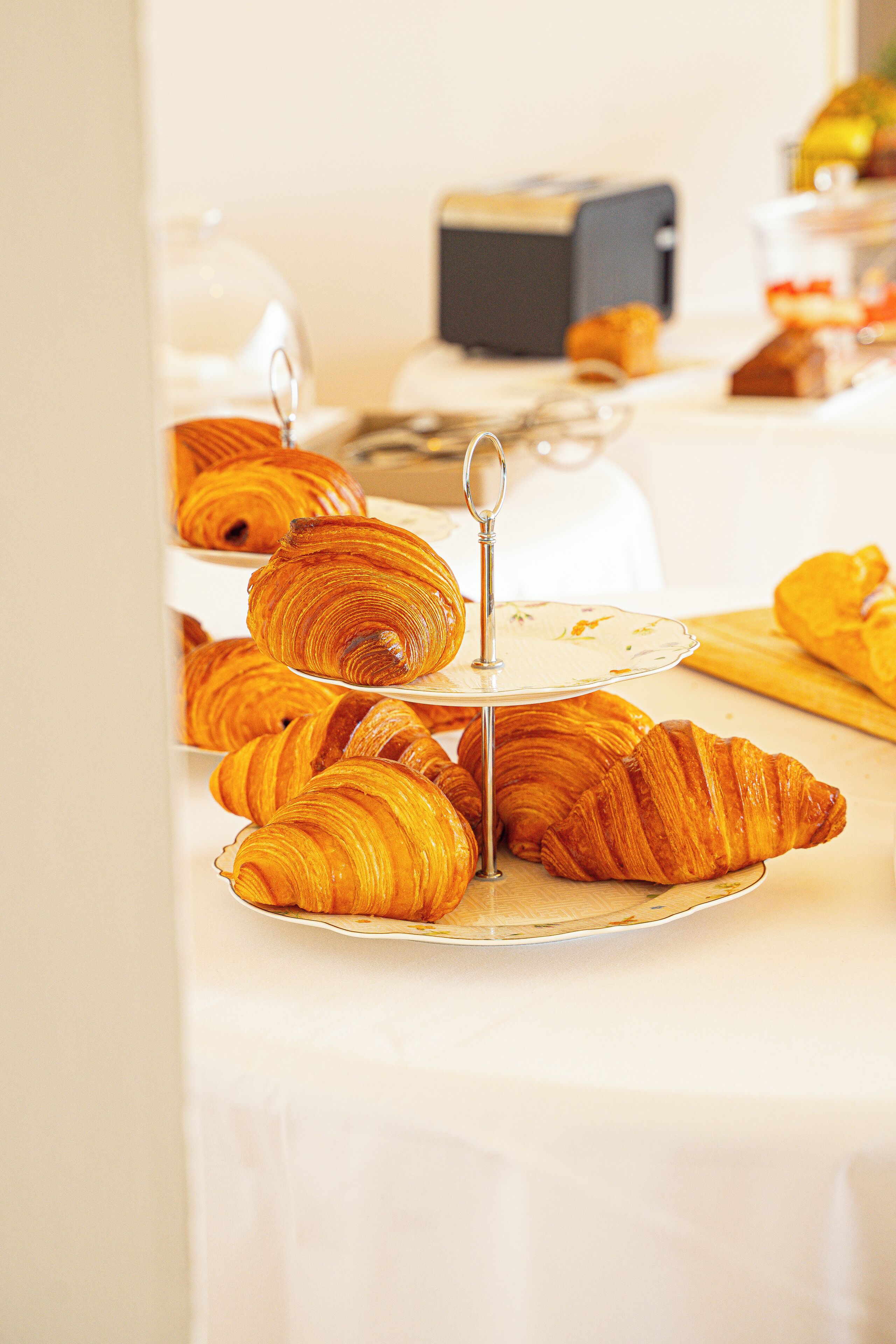 Een tafel met croissants op een presentatietafel en een broodrooster op de achtergrond.