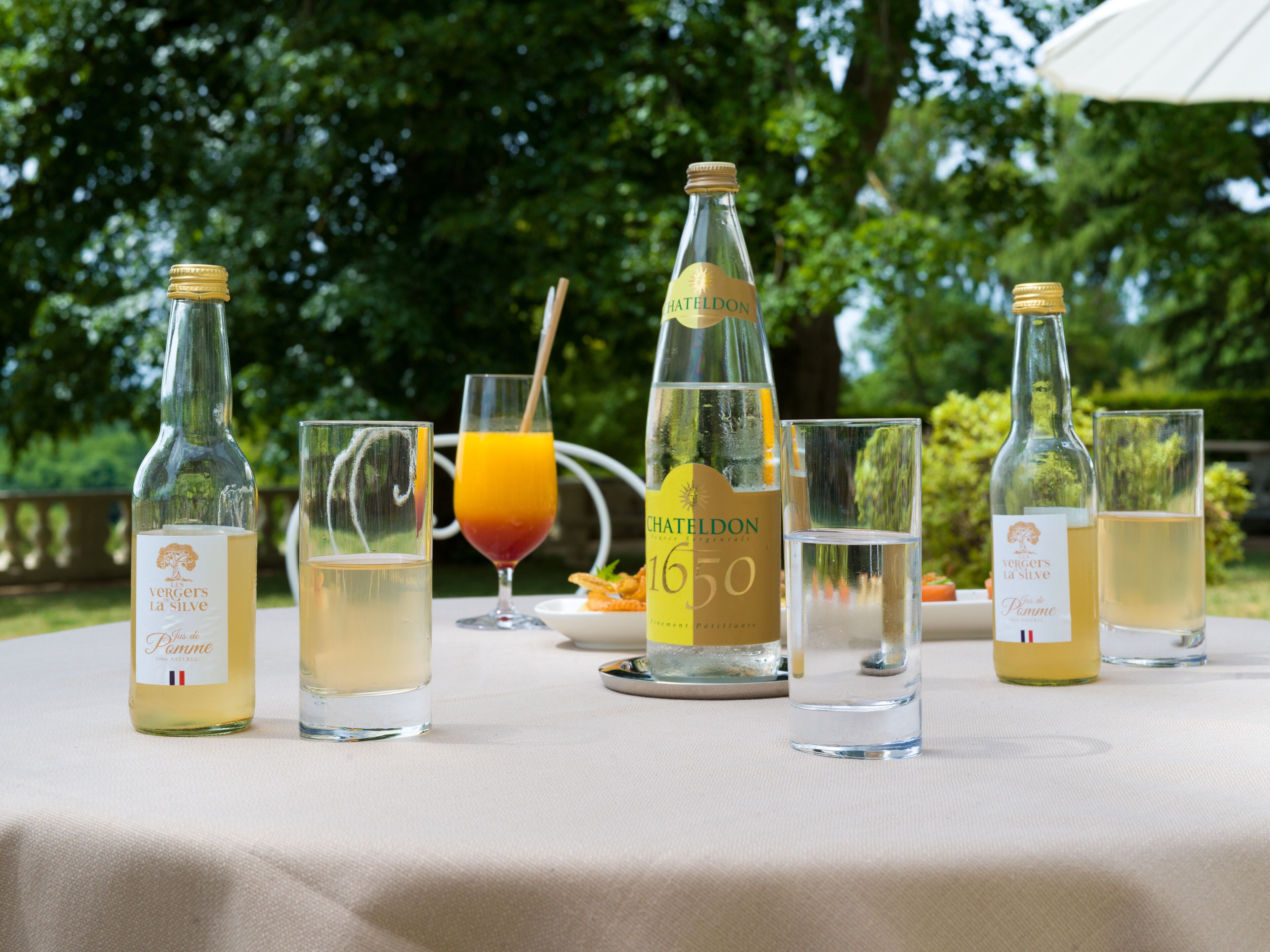 A table with various bottles and glasses of beverages, likely for a tasting event.