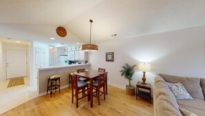 A compact living space with a dining area, kitchen, and a sofa. - Secluded Paradise Serene 2BR Golf Course Views (Pawleys Island)