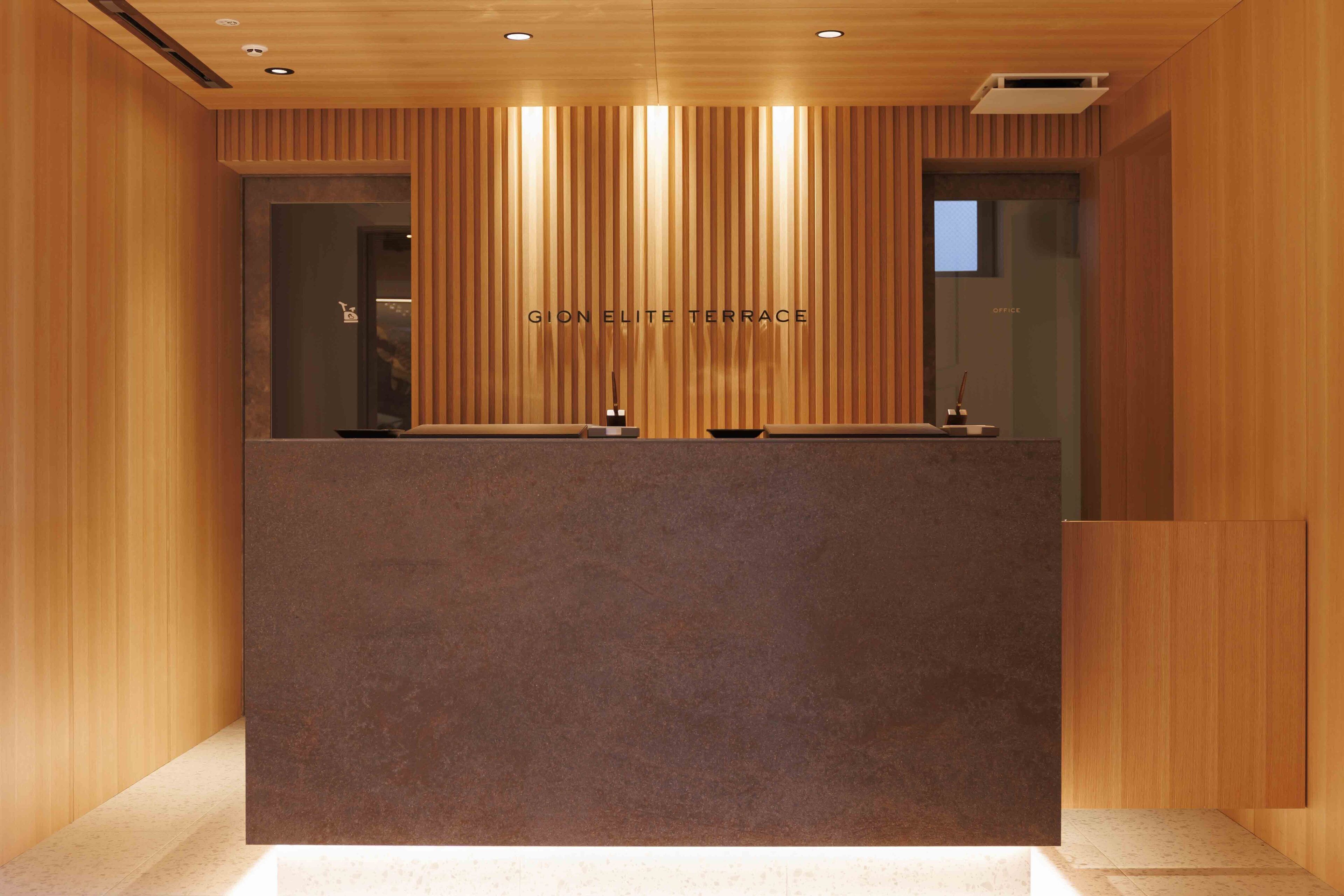 A reception desk with a wooden finish and a dark countertop.