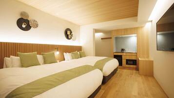 Habitación de hotel con dos camas, techo de madera, kitchenette y un espejo grande.