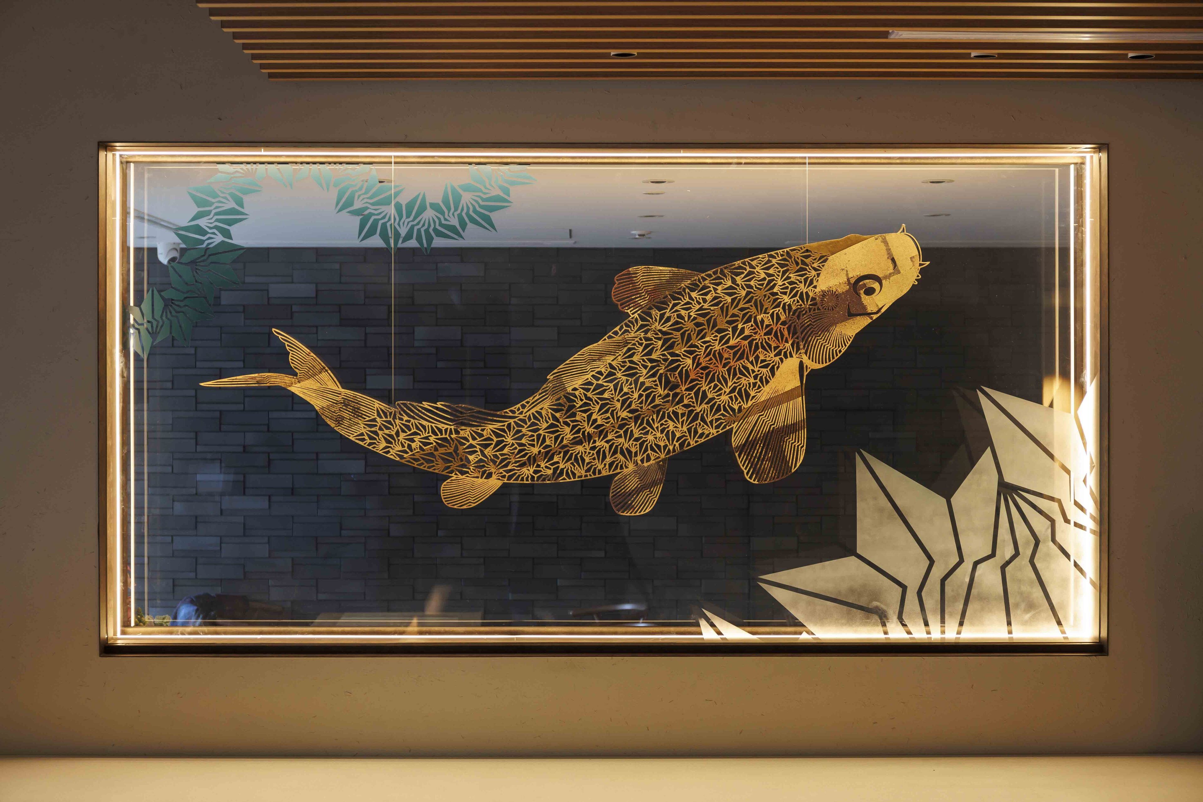 Una obra de arte enmarcada con un pez en la pared.