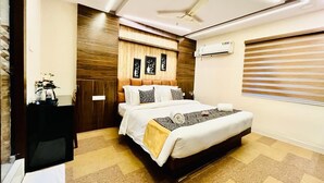 A hotel room with a bed, a ceiling fan, an air conditioning unit, and a window with blinds. - HOTEL SM RAINBOW INTERNATIONAL (Hyderabad)