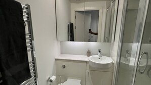 Une salle de bain moderne équipée de toilettes, d’un lavabo et d’une douche.