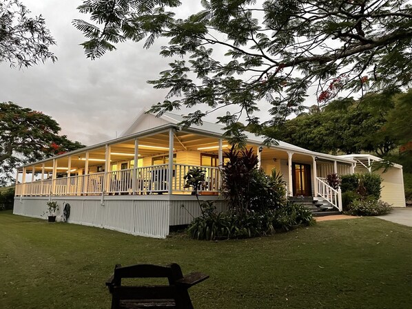 A two-story building with a covered porch and a staircase leading to the entrance.