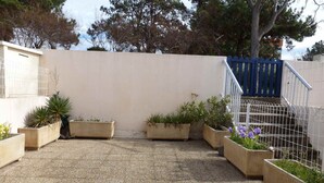 A courtyard with gravel flooring, surrounded by low walls and potted plants. - T2 Apartment in Balaruc-les-Bains, view of the pond, air-conditioned, private parking, WiFi (Balaruc-les-Bains)