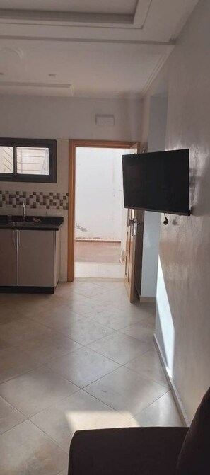 A modern kitchen with a tiled backsplash, a built-in oven, and a window.