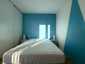 A bedroom with a bed, two bedside tables, and a window with blinds. - Renovated 2BR Apartment, Sleeps 5, City Center, Close to Beach, Parking, WiFi (Les Sables-d'Olonne)