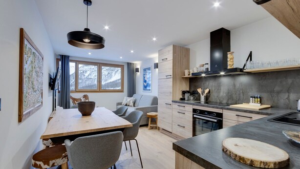 A modern kitchen with a central island, wooden cabinets, and a built-in oven. - Renovated apartment at the slopes, pets allowed (Val-d'Isère)