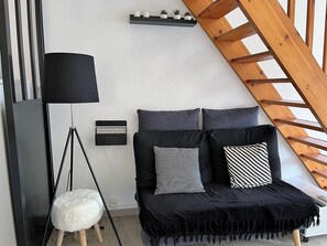Relax in a cozy bedroom with a comfortable bed, wooden ladder, and soft stool.