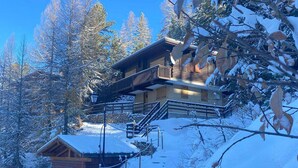A wooden cabin with a balcony, surrounded by snow-covered trees. - Cozy chalet near slopes with Wifi (La Plagne)