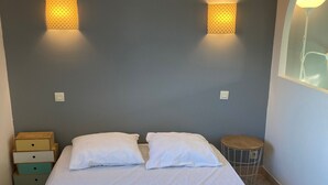 Ein Schlafzimmer mit einem Bett, zwei Nachttischen und zwei Wandlampen.