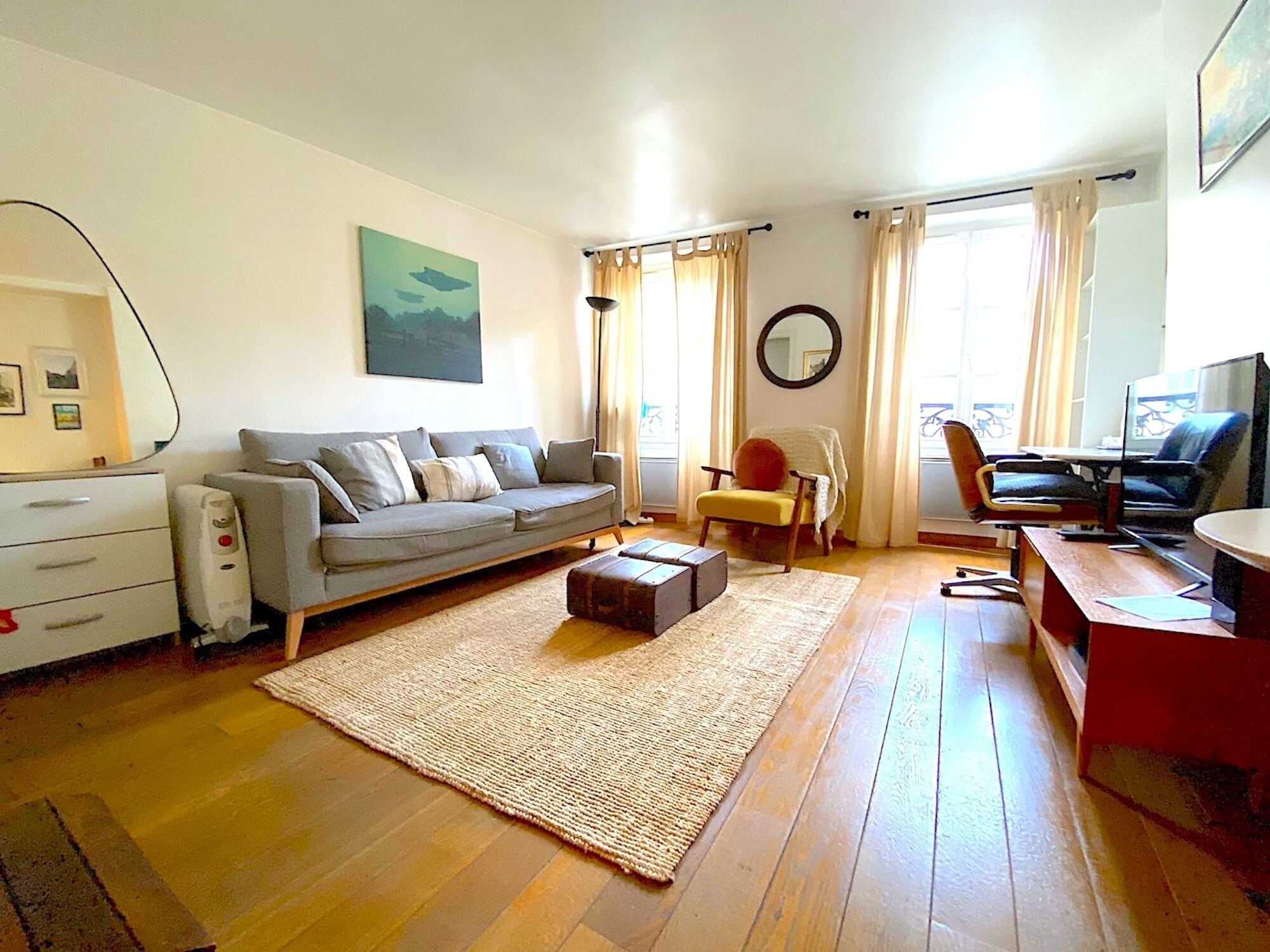 Una sala de estar con sofá, mesa de centro, televisor y escritorio con silla.