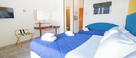 Una habitación de hotel con una cama grande, un escritorio, una silla, un televisor y un espejo.
