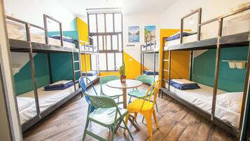 Un dormitorio con literas, una mesa redonda y sillas.