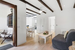 Un'ampia zona giorno con tavolo da pranzo, divano e ventilatore a soffitto.
