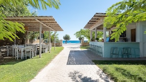 A pathway leading to outdoor seating areas with a view of the sea. - AFANDOU BAY SUITES HOTEL (Rhodes)