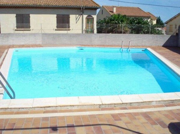 Guests can enjoy a refreshing swim in the pool surrounded by a tiled deck.