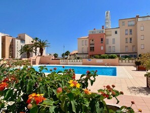 Una piscina circondata da vegetazione e edifici.