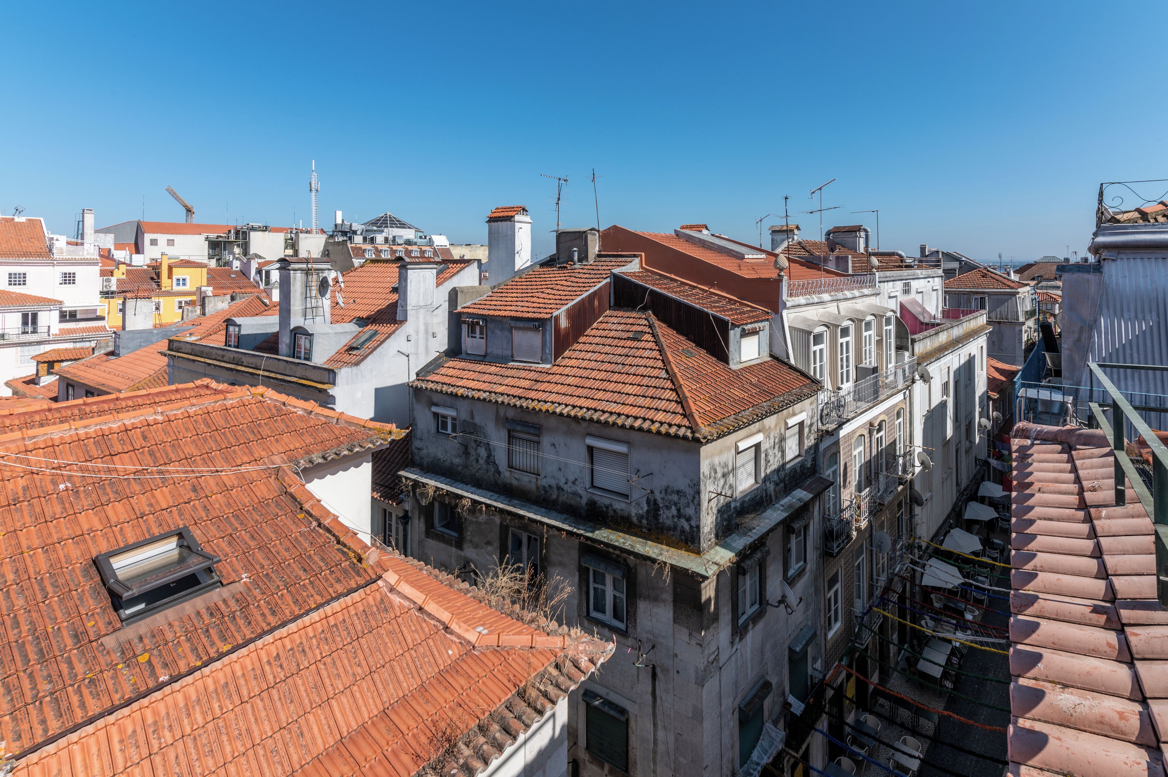 A cityscape with buildings featuring red-tiled roofs and a mix of architectural styles.