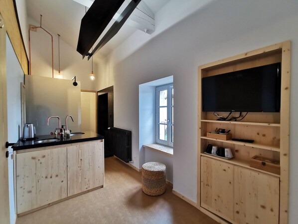 Ett modernt kök med en central köksö, inbyggda vitvaror och ett stort fönster.