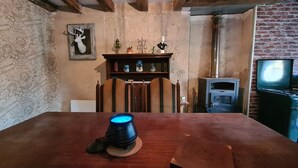 Une pièce chaleureuse avec une table en bois, une cheminée et un téléviseur.