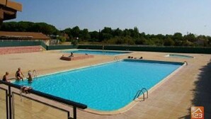 A swimming pool with multiple lanes, surrounded by a tiled deck area. - Spacious Home with Pool, Tennis, and Garden - Sleeps 10 (Vendres)