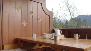 Een houten tafel met een karaf, bekers en een mand.