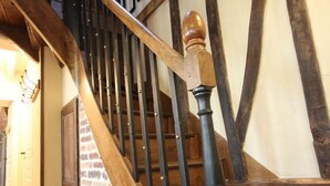 Eine Holztreppe mit schwarzem Geländer und einem Holnänder.