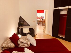 Ein Schlafzimmer mit Bett, Kissen, Schreibtisch und Stuhl.