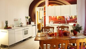 Eine moderne Küche mit weißen Schränken, einem Holztisch und einem großen Spiegel.