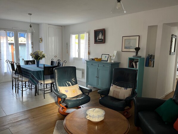 Una sala de estar con comedor, un aparador azul y una estantería.