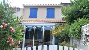 A two-story house with a tiled roof, blue shutters, and a white picket fence. - 4 Bedroom Villa, Sleeps 6, 800m from Beach, Parking, Verandas, Pets Allowed (Fleury-Saint-Pierre-la-Mer)