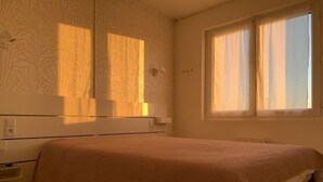A bedroom with a bed, a window, and a radiator. - Pleasant T3 with Air Conditioning and Wi-Fi, Balaruc-les-Bains (Balaruc-les-Bains)