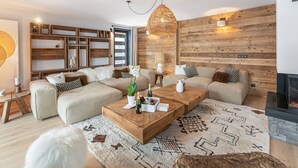 Un salon moderne avec un canapé d’angle, une table basse en bois et une cheminée.