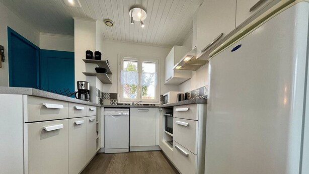 A compact kitchen with white cabinets, a dishwasher, an oven, and a refrigerator. - Quiet house, 3 rooms, garden, WiFi - La Brée-les-Bains (La Brée-les-Bains)