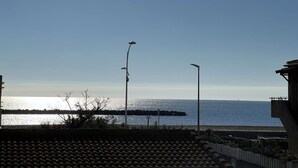 Une vue sur la côte, avec un ciel dégagé, une étendue d’eau et des lampadaires.
