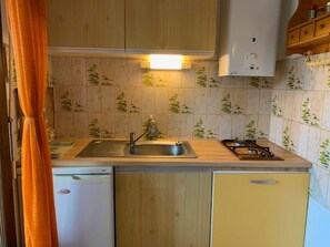Uma cozinha compacta com pia, fogão e armários.