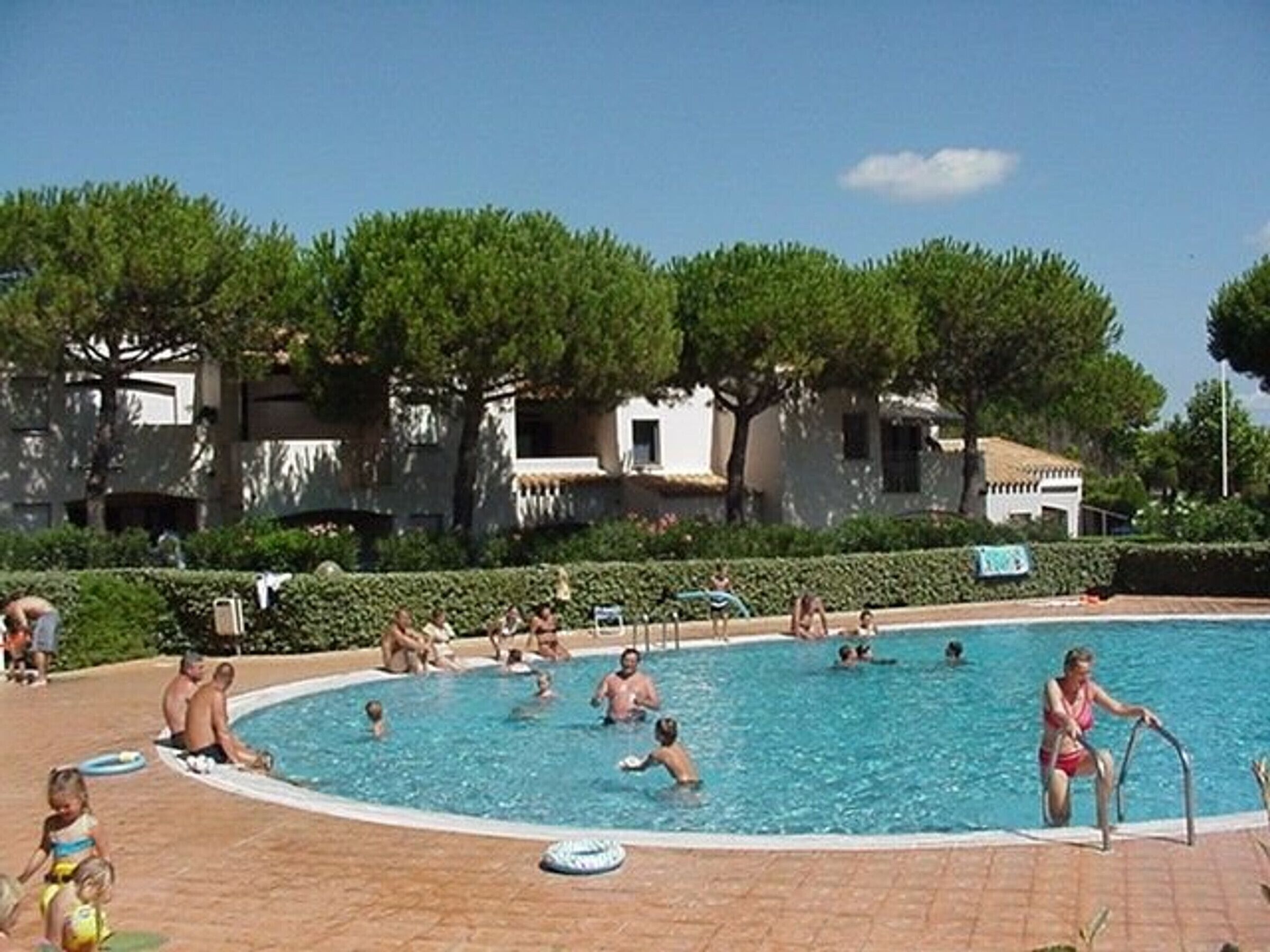 A swimming pool surrounded by trees and buildings.