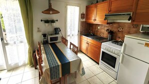 Una cocina compacta con armarios de madera, una estufa, un microondas y un refrigerador.