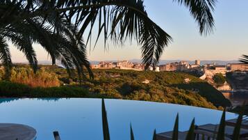 A pool with a view of a cityscape and mountains in the background.