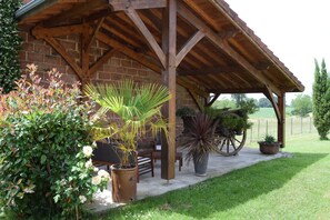 Relax in a serene pavilion surrounded by lush greenery and a well-manicured lawn.