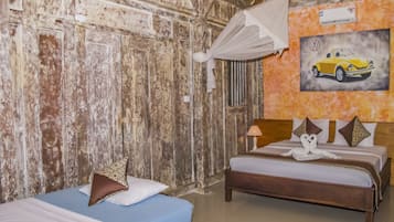 Una habitación con paredes de madera rústica, una cama con ropa de cama blanca y azul, una mesita de noche con una lámpara y un cuadro de un coche en la pared.
