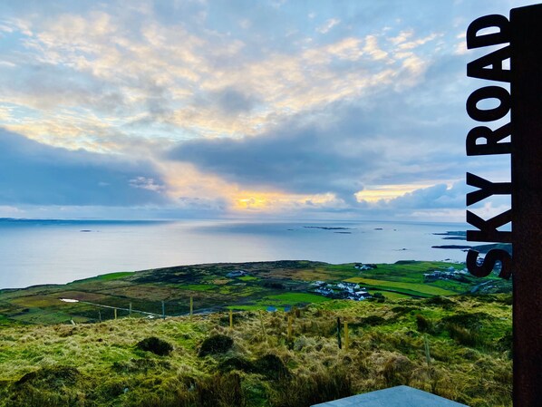 A scenic view of Sky Road with a coastal landscape and rolling hills.