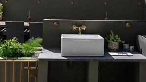 A rooftop patio with a white sink, outdoor seating, and a view of the sky and trees. - Clifden's premier holiday home with heated pool + sauna - sleeps 24 (Clifden)