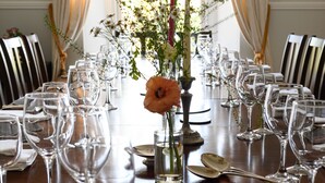 A dining table set for a formal meal with multiple wine glasses and a centerpiece of flowers. - Clifden's premier holiday home with heated pool + sauna - sleeps 24 (Clifden)