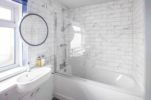 Regadera, secadora de cabello, toallas, papel de baño 
